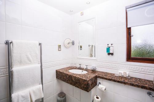 a white bathroom with a sink and a shower at The Moat House in Stafford