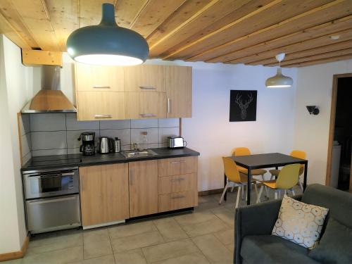 uma cozinha e sala de jantar com mesa e cadeiras em Appartement dans ferme rénovée au cœur du Grand Massif em Sixt