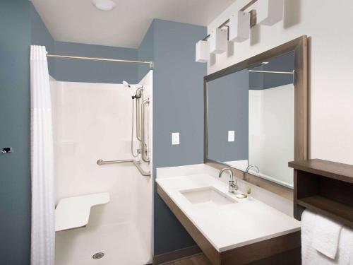 a bathroom with a sink and a mirror at LikeHome Extended Stay Hotel Columbus in Columbus