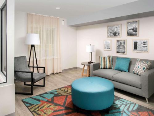 a living room with a couch and a blue stool at WoodSpring Suites Atlanta Conyers in Conyers
