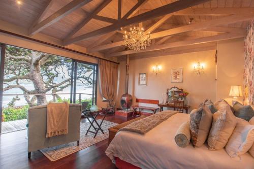 Un dormitorio con una cama grande y una lámpara de araña. en Tintswalo Atlantic, en Hout Bay