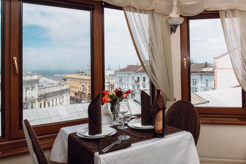 a table with a view of the city from a window at Ekaterina II Hotel in Odesa