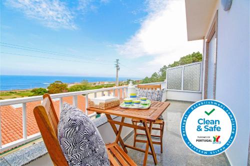 a balcony with a table and chairs and the ocean at Vila Lucia in Vila Praia de Âncora