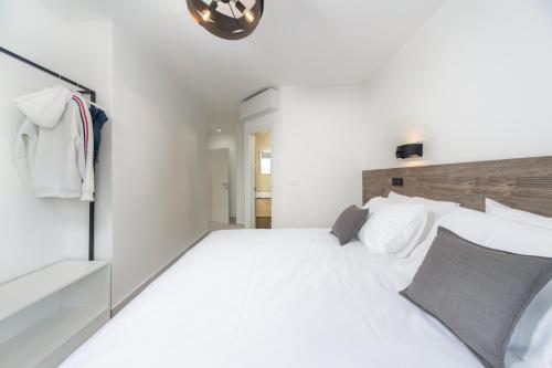 a white bedroom with a large white bed with pillows at VILLA FUX ZRCE Novalja - direkt am Strand in Časka