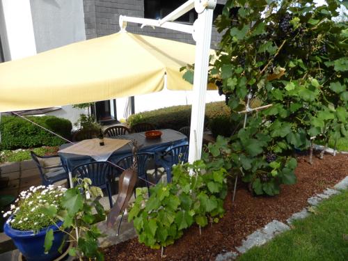 a table with a yellow umbrella in a garden at Hotel Leitgebhof in Innsbruck