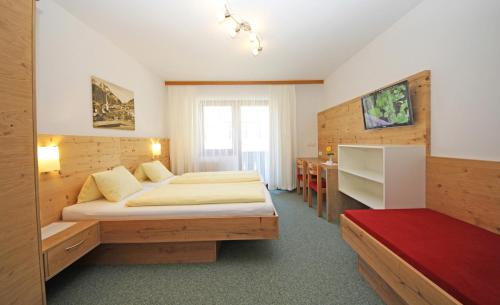 ヴィルゲンにあるGasthof Pension Roseのベッドとデスクが備わるホテルルームです。