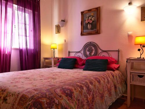 a bedroom with a large bed with red pillows at Quinta Infantes de Santa Maria in Alcantarilha