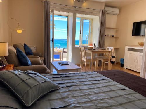 a bedroom with a bed and a view of the ocean at Luz Beach Apartments in Luz