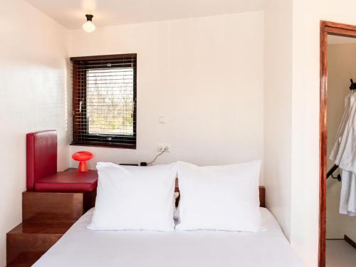 a bedroom with a white bed and a red chair at SWEETS - IJdoornlaanbrug in Amsterdam