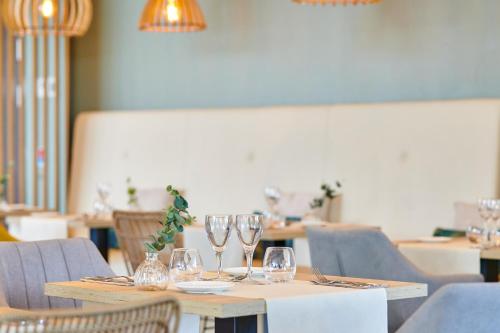 a table with wine glasses on it in a restaurant at Les Terrasses d'Atlanthal in Anglet