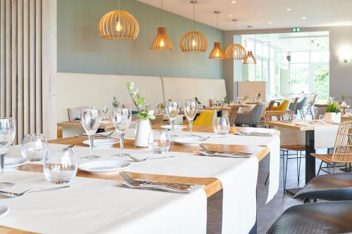 a dining room with tables and chairs and chandeliers at Les Terrasses d'Atlanthal in Anglet