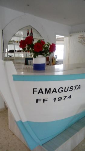 a boat with red flowers on a table at Flokkas Hotel Apartments in Protaras