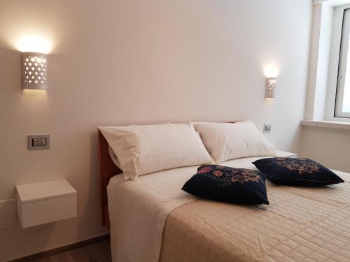 een slaapkamer met een bed met 2 kussens erop bij RosAmar in Bari
