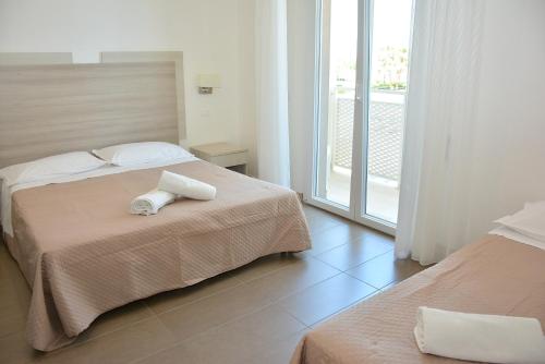 a hotel room with two beds and a balcony at Hotel Marisa in Riccione