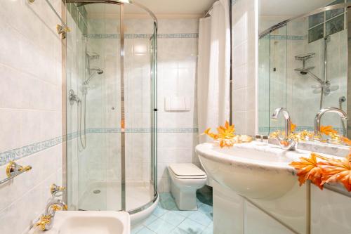 ein Bad mit einer Dusche, einem Waschbecken und einem WC in der Unterkunft Uffizi Place in Florenz
