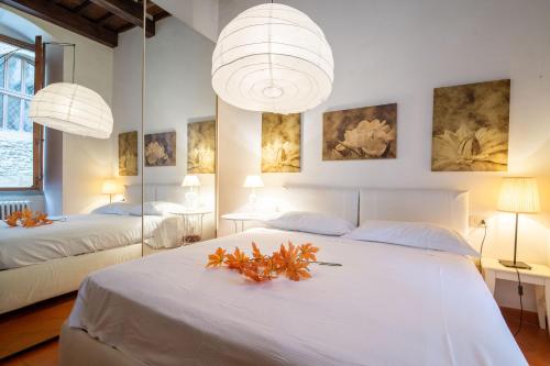 ein weißes Schlafzimmer mit 2 Betten und 2 Lampen in der Unterkunft Uffizi Place in Florenz