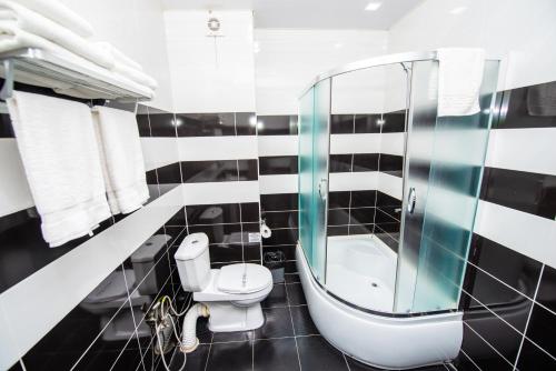 a black and white bathroom with a toilet and a mirror at Hotel Shine Palace in Tbilisi City