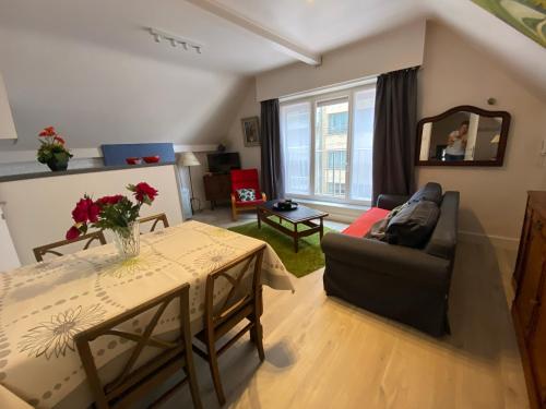 ein Wohnzimmer mit einem Sofa und einem Tisch in der Unterkunft Apartment Van Hecke in Blankenberge