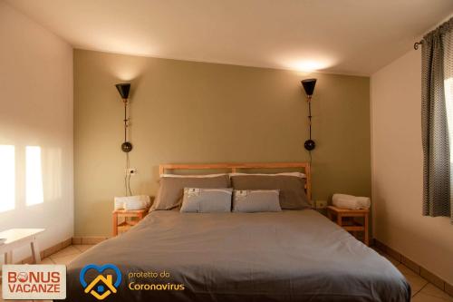 a bedroom with a bed with two lamps on the wall at Livingapple in Scauri