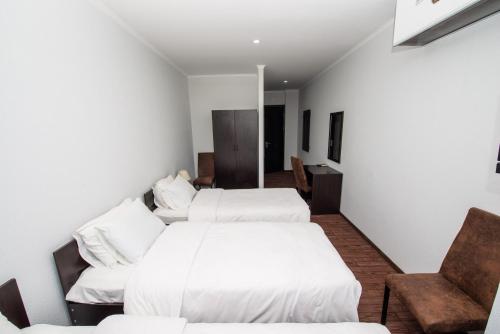 a hotel room with two beds and a chair at Hotel Shine Palace in Tbilisi City