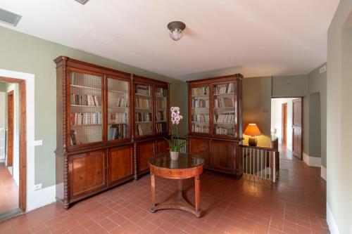 a room with a table with a vase of flowers on it at Agriturismo La Fattoria di Capezzana in Carmignano