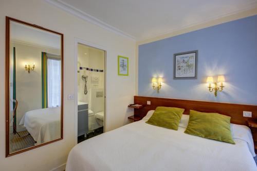 a bedroom with a bed and a large mirror at Hôtel La Sanguine in Paris