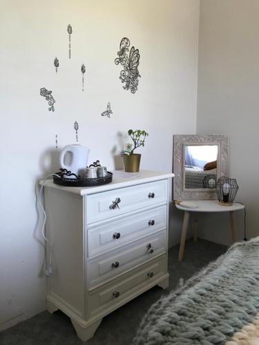 een witte dressoir met een spiegel in een slaapkamer bij Relais de la poste in Monclar-de-Quercy