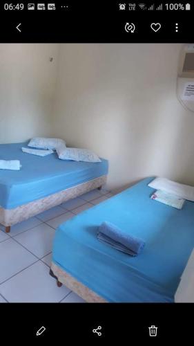 two beds in a room with blue sheets at Pousada Sossego Salinas in Salinópolis