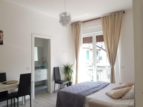 a bedroom with a bed and a desk and a window at Fior&Iris Apartments in Stresa