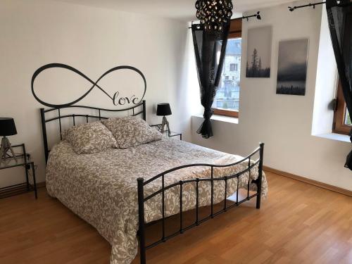 sypialnia z łóżkiem z zagłówkiem z kutego żelaza w obiekcie chez Suzanne w mieście Chooz