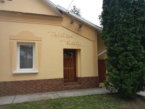 Una casa con un cartel en el costado. en Karikatúra Vendégház en Szentes