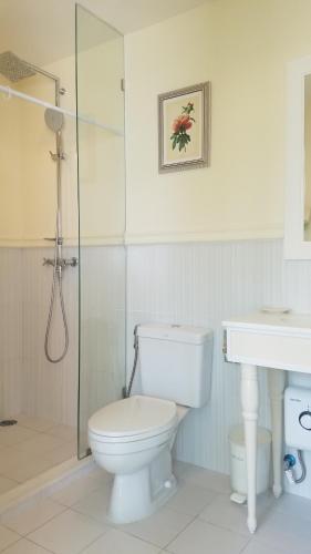 a bathroom with a toilet and a shower and a sink at Summer Huahin Condo by Howard in Hua Hin