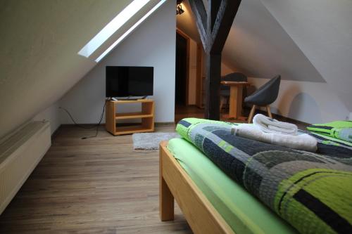a attic bedroom with a bed and a television at Turmgaststätte Löbau in Löbau