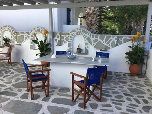 a patio with blue chairs and a table on a patio at Marioly Studios in Parikia