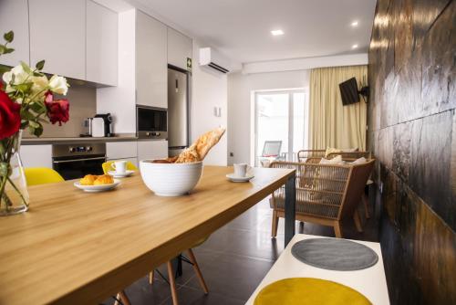 a kitchen with a wooden table with a bowl of bread at Terrazzos do Prado - Vista Ria de Aveiro in Costa Nova