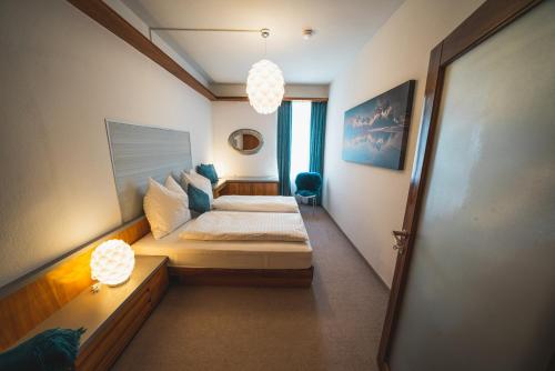 1 dormitorio con 1 cama y 2 lámparas. en Dolomitenmannapartments, en Lienz