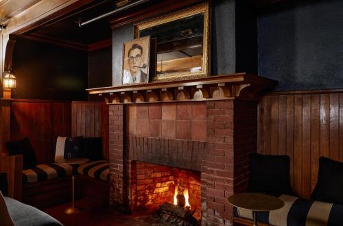 a fireplace in a restaurant with a mirror above it at Blind Tiger Portland - Danforth Street Guest House in Portland