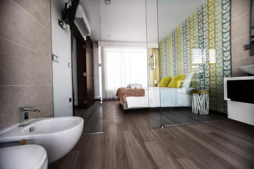 a bathroom with a sink and a bed in a room at Terrazzos do Prado - Vista Ria de Aveiro in Costa Nova