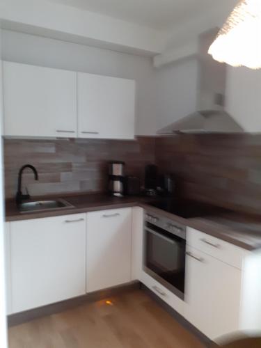 a kitchen with white cabinets and a stove top oven at Ferienwohnung Busdorf in Busdorf