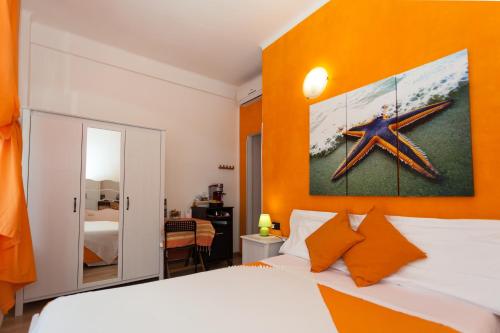 una camera da letto con parete arancione, letto e specchio di Stella Marina a Camogli