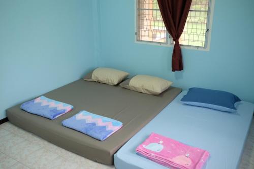 a blue room with a bed with two pillows at Little B house in Ban Tao Than