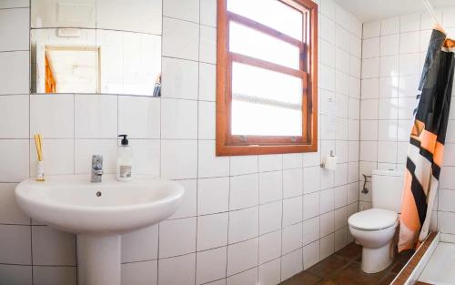a bathroom with a toilet, sink, and bathtub at Casa Grande Surf Hostel in El Médano