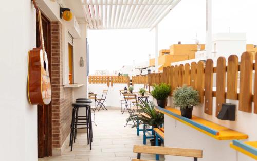 a patio with tables and chairs on a building at Casa Grande Surf Hostel in El Médano