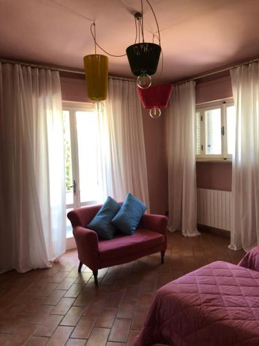 a bedroom with a couch and a bed and windows at Villa Barbara in Santa Luce