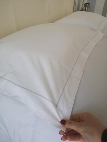 a person is wrapping a piece of white paper on a bed at Gruppo Luxe Domus Vigevano in Vigevano
