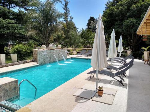 a pool with umbrellas and chairs and a swimming pool at Pualy Resort & Spa in Belén de Escobar