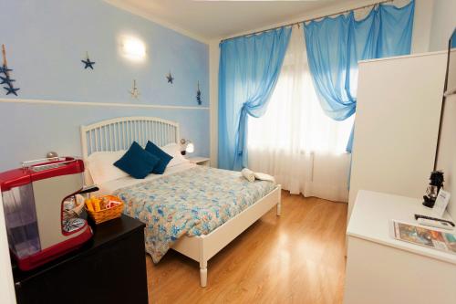 a bedroom with a bed and a window with blue curtains at Stella Marina in Camogli