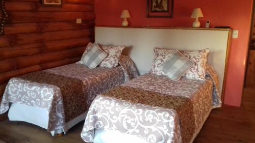 two beds in a room with red walls at Pualy Resort & Spa in Belén de Escobar
