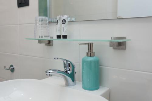 a bathroom with a blue soap dispenser on a sink at Stella Marina in Camogli