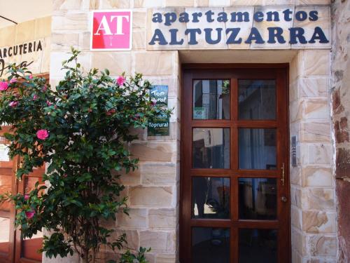 a building with a door and a sign on it at Apartamentos Rurales Altuzarra in Ezcaray